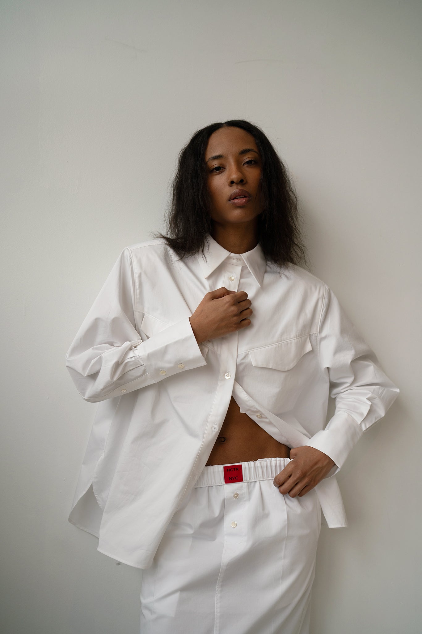 HCTR Oversized Cotton Poplin Button Down in White — portrait view showing flap breast pockets and poplin drape