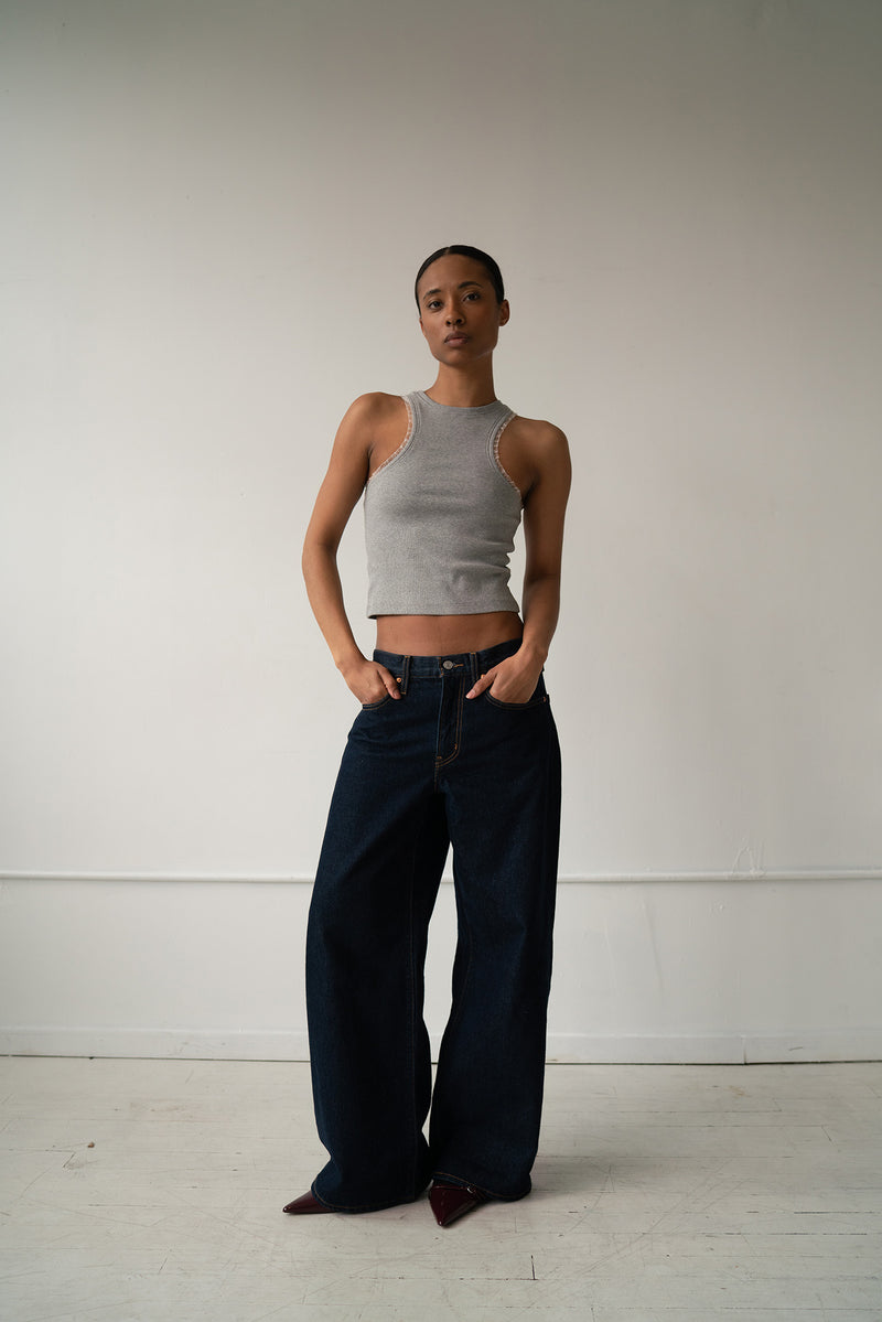 HCTR Dual-Neckline Reversible Ribbed Tank in Grey — full front view styled with dark wide-leg jeans, hands in pockets