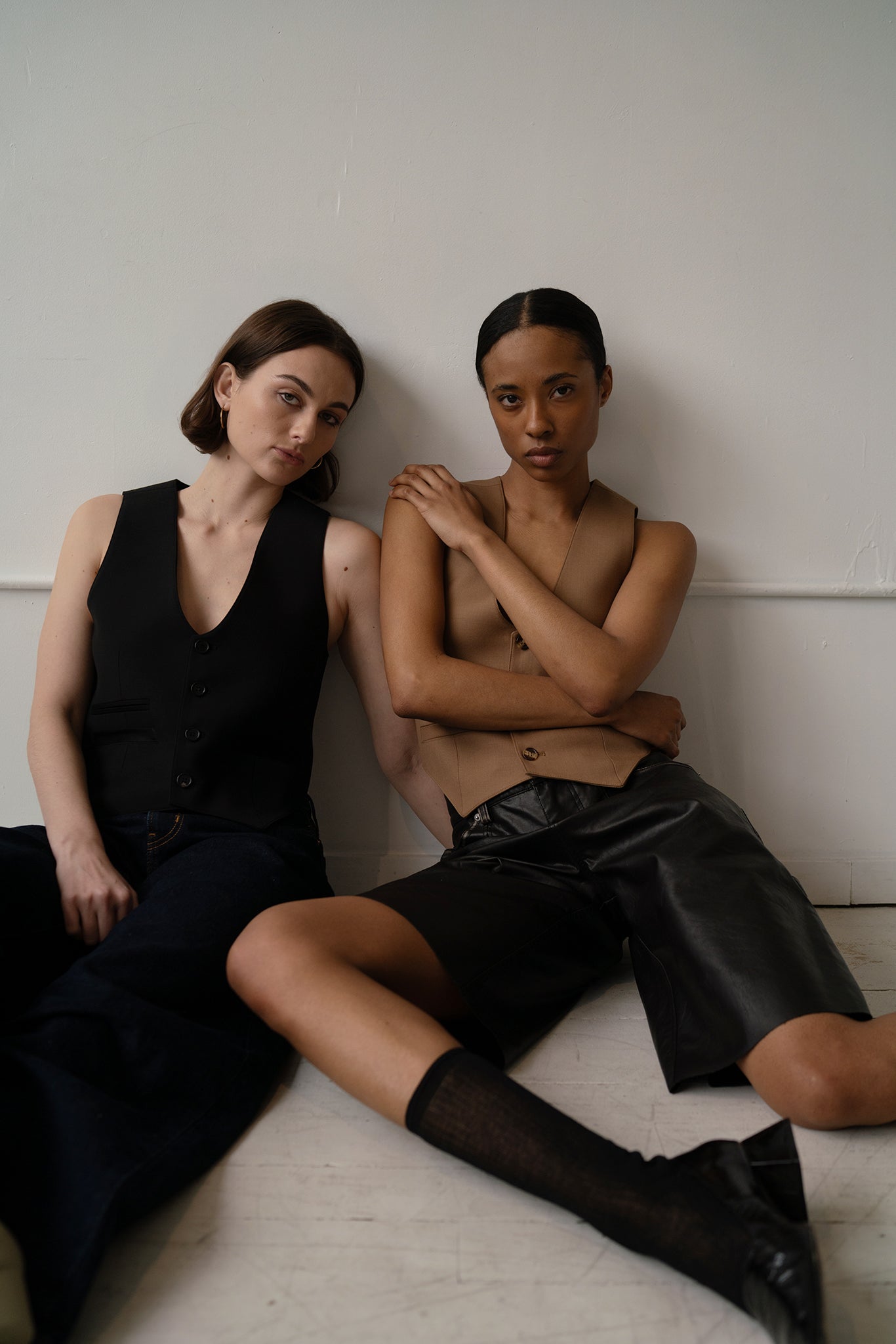 HCTR Modular 100% Wool Waistcoat in Onyx and Saddle Brown — two-model lower body shot showing pointed wool hem and contrast styling